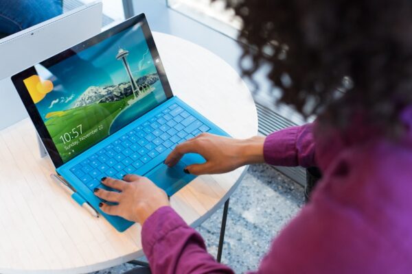 Persona usa laptop con tastiera blu
