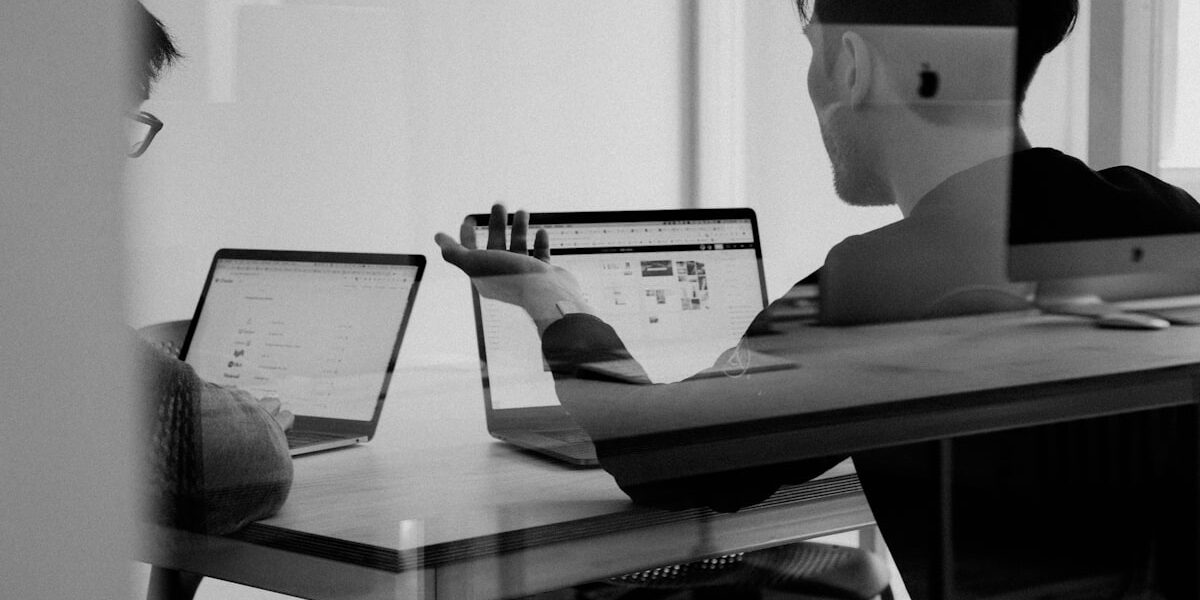 Persone discutono davanti ai laptop