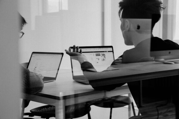 Persone discutono davanti ai laptop