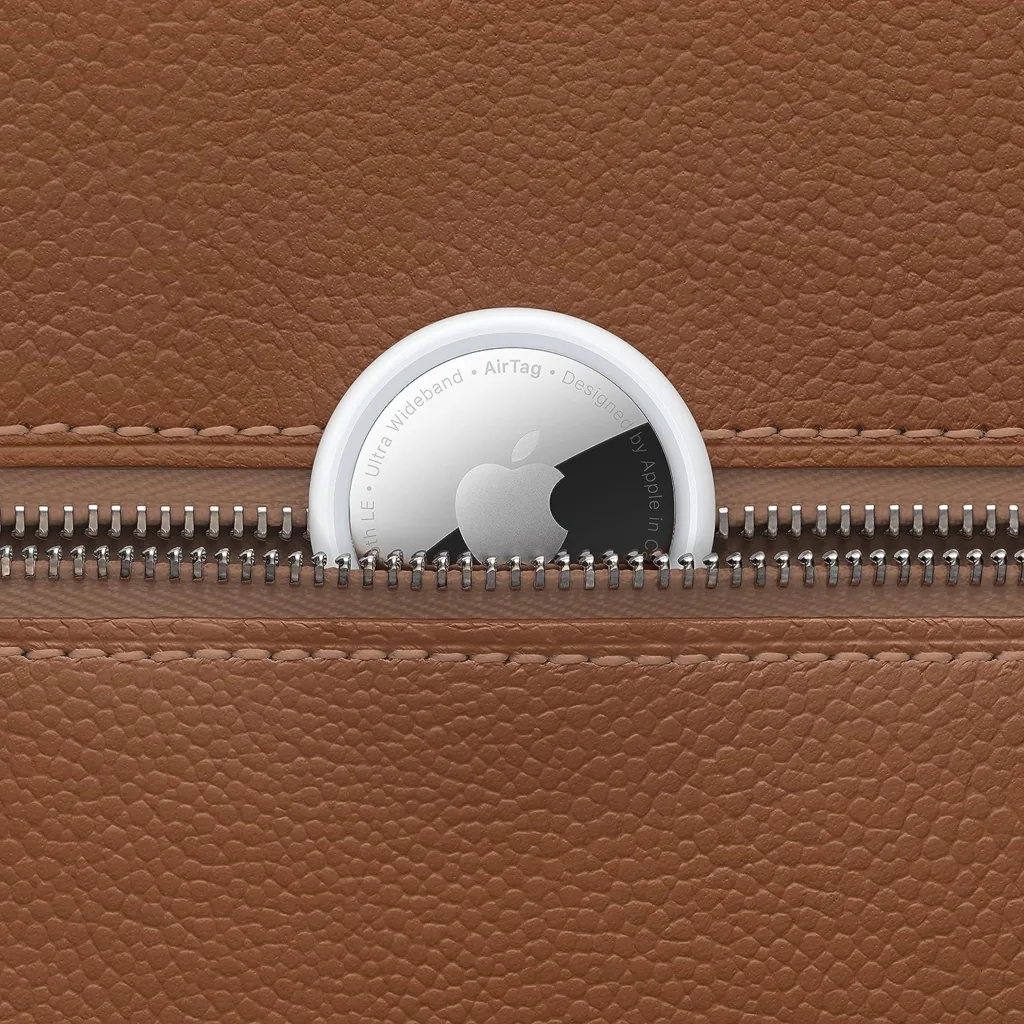 Apple AirTag sur une surface en cuir marron.